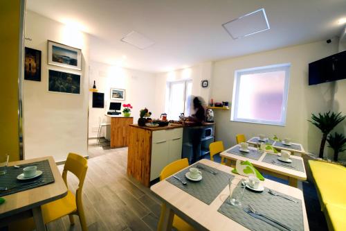 a living room with tables and chairs and a kitchen at NicaDomus B&B in Licata