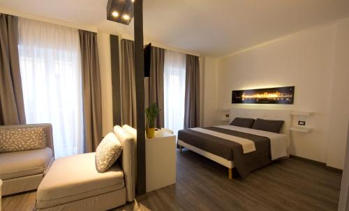 um quarto de hotel com uma cama e um sofá em NicaDomus B&B em Licata