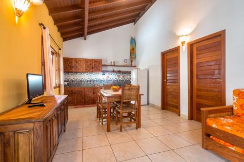 a kitchen with a table and a dining room at Capoeira Village in Porto Seguro