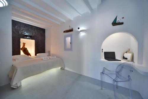 a bedroom with a bed and a laptop on the wall at AMO Folegandros in Karavostasi