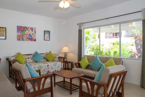 a living room with a couch and a table at Antigua Village Beach Resort in Saint Johnʼs