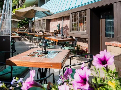 an outdoor patio with tables and chairs and flowers at Kings Inn in San Diego