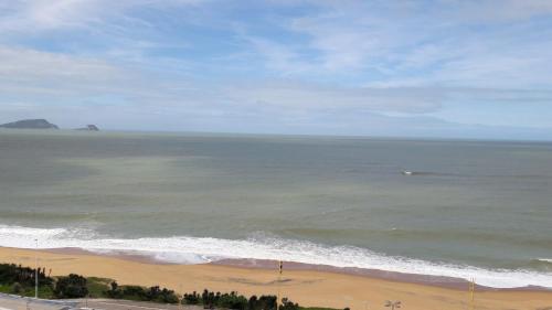 an ocean view of a beach with a boat in the water at Bonjour Hotel in Macaé
