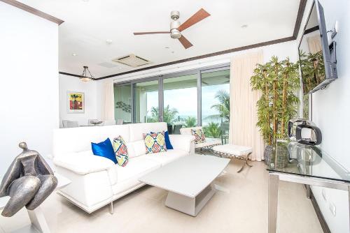 a living room with a white couch and a table at Best in Jaco Condos at Diamante del Sol in Jacó