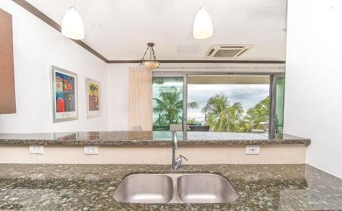 a kitchen with a sink and a large window at Best in Jaco Condos at Diamante del Sol in Jacó