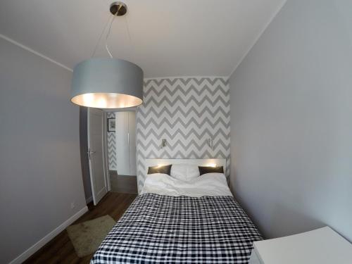 sypialnia z łóżkiem z kocem szachowym w obiekcie Apartament Garazowa 5 w Warszawie