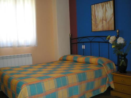 1 dormitorio con 1 cama y un jarrón de flores en Apartamentos Augusta Centro en Zaragoza