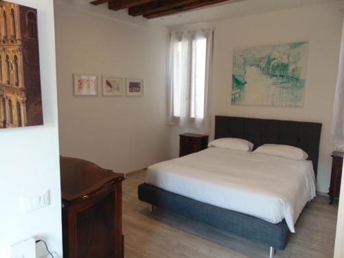 Un dormitorio con una cama blanca y una ventana. en Ca' Sansovino, en Venecia