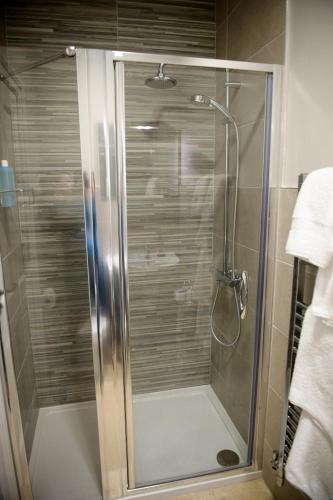 a shower with a glass door in a bathroom at Bank House B&B in Bishops Castle