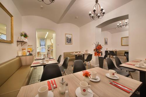 ein Restaurant mit Tischen und Stühlen in einem Zimmer in der Unterkunft Hotel Suite Home Prague in Prag