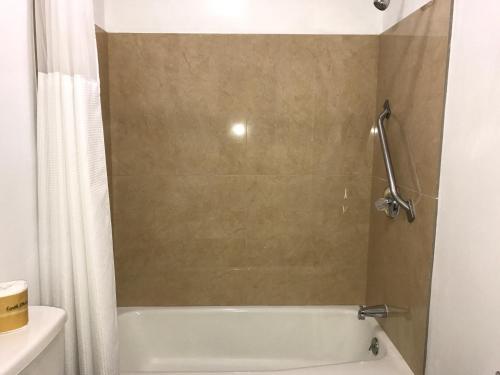 Chief Motel في Keokuk: حمام مع حوض استحمام أبيض ودش