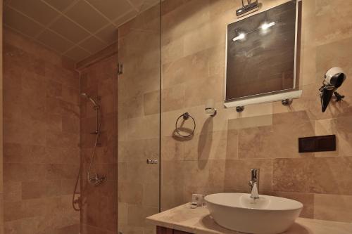 a bathroom with a tub, sink and mirror at Guzide Cave Hotel in Goreme