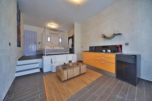 a living room with a kitchen and a bathroom at AMO Folegandros in Karavostasi