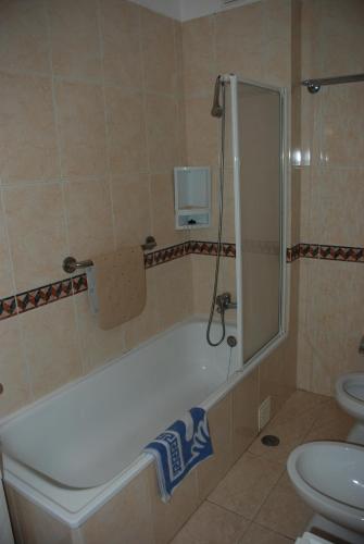 a bathroom with a bath tub and a toilet at Terraço e Mar in Alvor