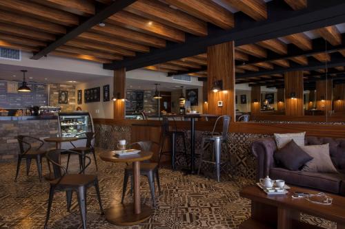 a restaurant with a couch and tables and a bar at Krystal Grand Los Cabos - All Inclusive in San José del Cabo