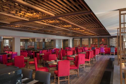 a dining room with red chairs and tables at Krystal Grand Los Cabos - All Inclusive in San José del Cabo