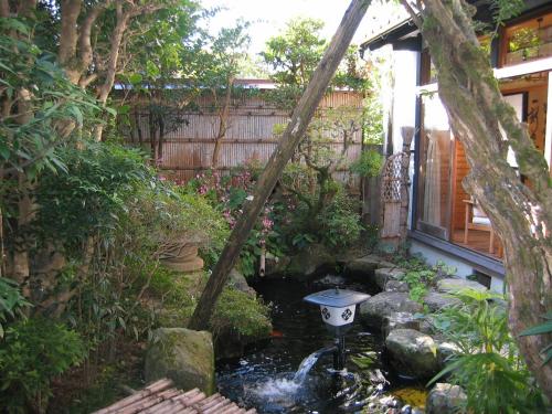 a garden with a bird bath in the middle of a pond at Noren Yado Meigetsu in Tsuwano