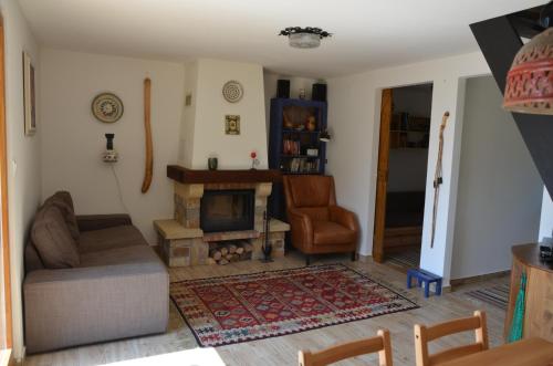 a living room with a couch and a fireplace at Őzgida Nyaralóház in Zebegény