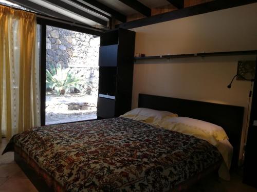 a bedroom with a bed and a large window at Lily house in Gravina di Catania