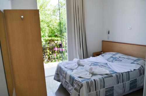 a bedroom with a bed and a window with a view at Pousada Omnimare in Ubatuba