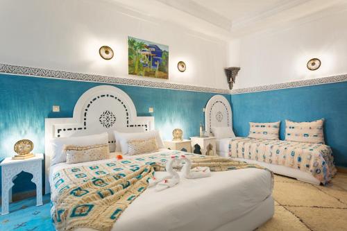 una camera con due letti e pareti blu di Astra Damus Hotel a Marrakech