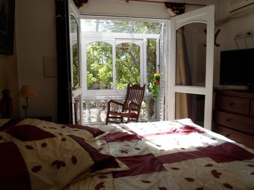 a bedroom with a bed and an open window at La Casona de Susana in Colón