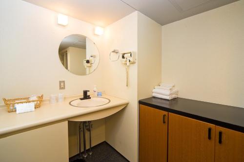 uma casa de banho com um lavatório e um espelho em The Residential Suites Fukuoka em Fukuoka