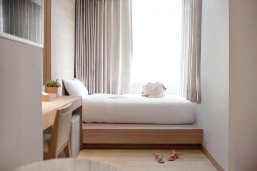 a bedroom with a bed and a window with two dogs on the floor at Kritthai Residence in Bangkok