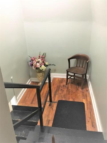 a room with a table and a chair and a vase of flowers at Vineyard Mansion Carriage House in Saint Joseph