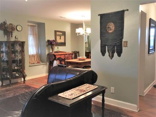 a living room with a leather couch and a table at Vineyard Mansion Carriage House in Saint Joseph