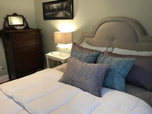 a bedroom with a white bed with blue pillows at Vineyard Mansion Carriage House in Saint Joseph