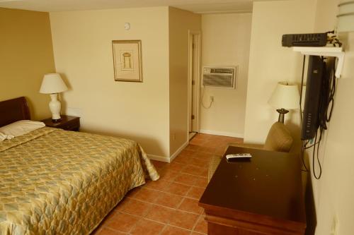 una habitación de hotel con una cama y un televisor en Sea Cove Motel Ocean City, en Ocean City