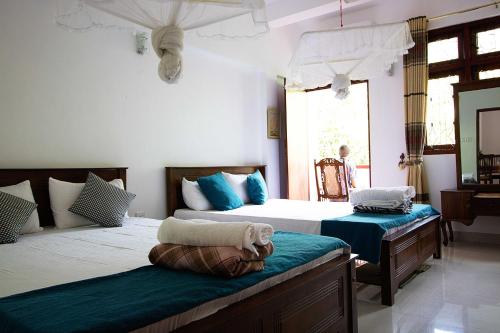 a bedroom with two beds and a mirror at Hanthana Jungle View Holiday Home in Kandy