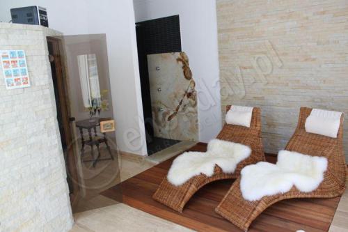 a living room with three wicker chairs and a fireplace at Rewa in Rewal