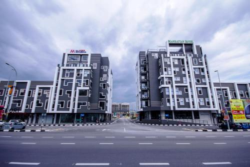 dois edifícios altos ao lado de uma rua em Manhattan Hotel Ipoh em Ipoh