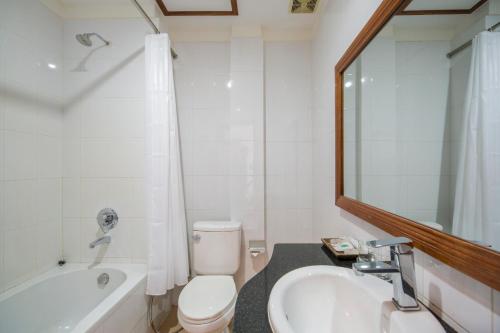 a bathroom with a toilet and a tub and a sink at Kouprey Hotel in Siem Reap