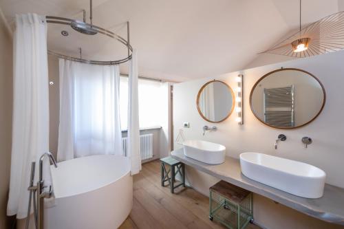 un bagno con 2 lavandini, vasca e specchi di Villa Paradiso Charme&Design ad Arquata Scrivia