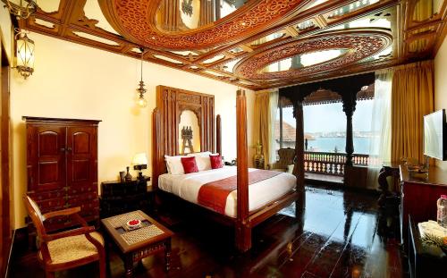 a bedroom with a bed with a ornate ceiling at Ginger House Museum Hotel in Cochin