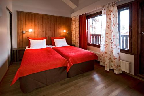 Un dormitorio con una cama con una manta roja y una ventana. en Holiday Club Ruka Village, en Ruka