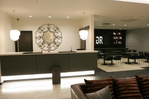 a salon with a couch and a bar in a room at Green Rich Hotel Nishitetsu Ohashi Ekimae in Fukuoka