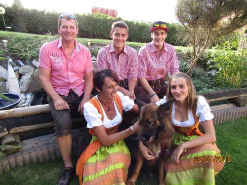 a group of people sitting on a fence with a dog at Ladis Living in Ladis
