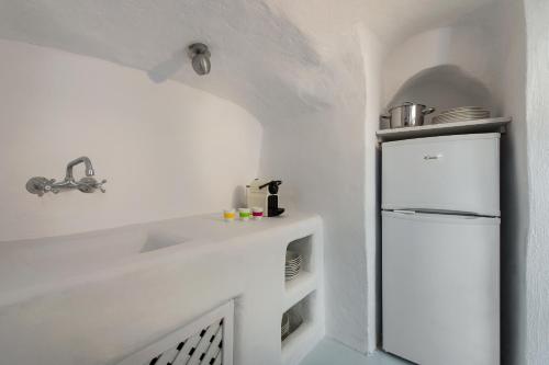 a white kitchen with a white refrigerator in a room at Artia Mansion in Oia