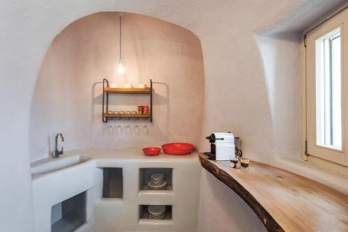 une cuisine avec un comptoir, un évier et une fenêtre dans l'établissement Ammos Oia Mansion, à Oia