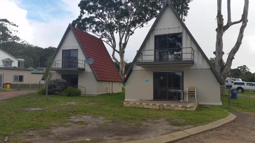 a house with a red roof and a balcony at Walpole Rest Point Caravan Park in Walpole
