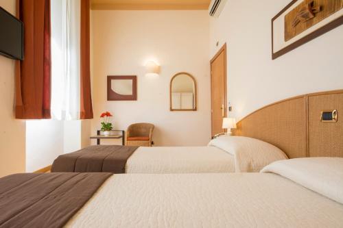 a hotel room with two beds and a chair at Piazza Paradiso Accommodation in Siena