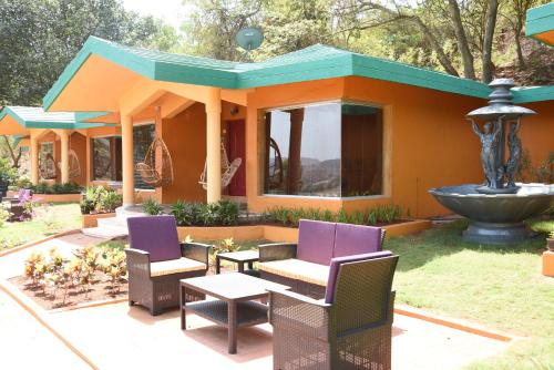 a house with chairs and a fountain in the yard at Residency Lake Resort & Spa in Mulshi