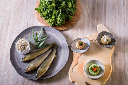 two plates of food on a table with vegetables at Setre Marina Biwako in Moriyama