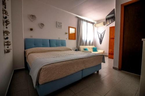 a bedroom with a blue bed in a room at Domna Studios in Líndos