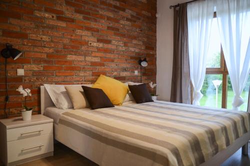 a bed in a room with a brick wall at Villa Harmony in Paradise in Svetvinčenat