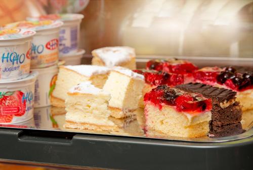 a tray of cakes and other desserts in a refrigerator at Hotel Opera in Sopot